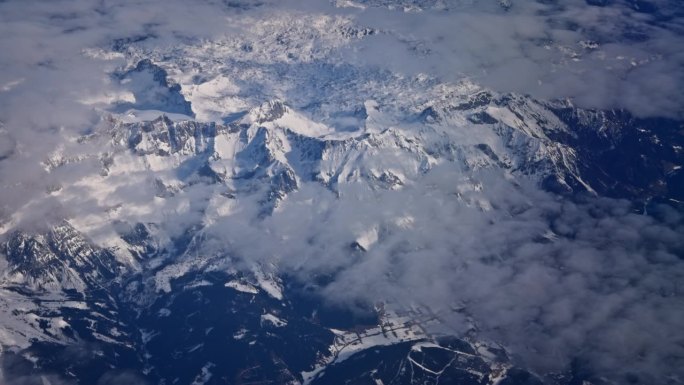飞行与飞机在蓬松的白色积云和雪山高峰高空大气视频
