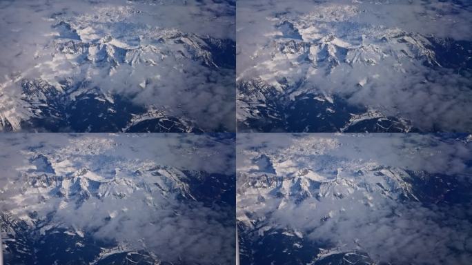 飞行与飞机在蓬松的白色积云和雪山高峰高空大气视频