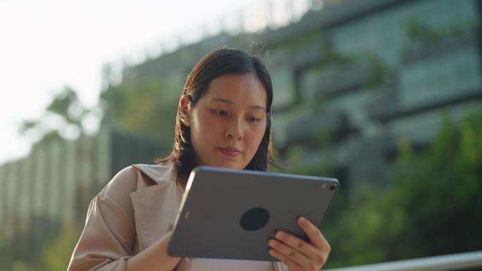 亚洲女商人在办公室外使用数码平板电脑