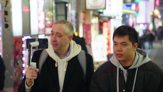 晚上与亚洲朋友在日本新宿散步时手持拍摄的游客视频