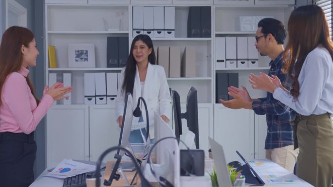 亚洲年轻商人和女商人一起拍手。吸引员工，员工感到快乐，相互激励，团结合作，在公司讨论项目。