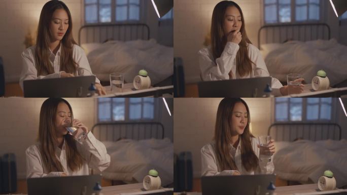 疲惫不堪的亚洲年轻女子工作过度，晚上还要吃药。迷人的女商人在家里的卧室里用笔记本电脑上网时感到恶心和
