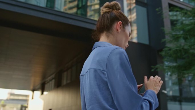 一名女子在现代市区使用手机应用程序查找位置。