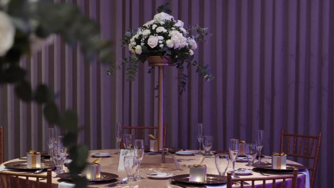 用鲜花和水晶餐具装饰的圆形宴会桌
