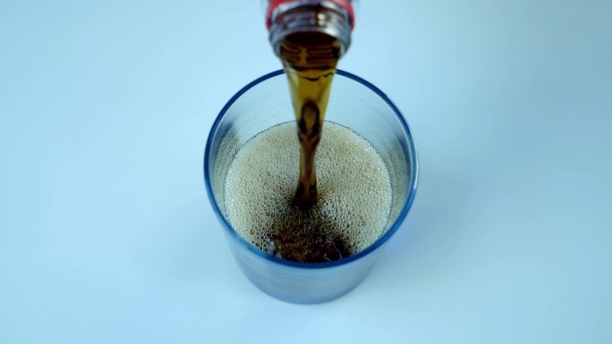 清爽甜美的碳酸水从塑料瓶倒进玻璃杯