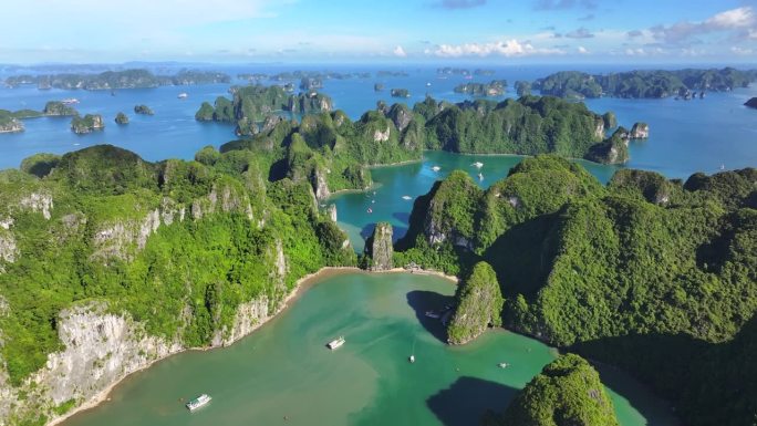 在越南北部下龙湾的海上，航拍无人机拍摄的观光船与岩石山的淡蓝色天空