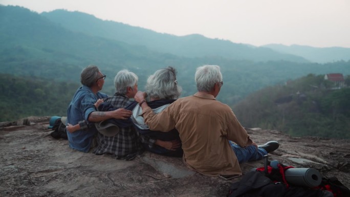 一群老人徒步旅行，一边背包旅行，一边呼吸新鲜空气。