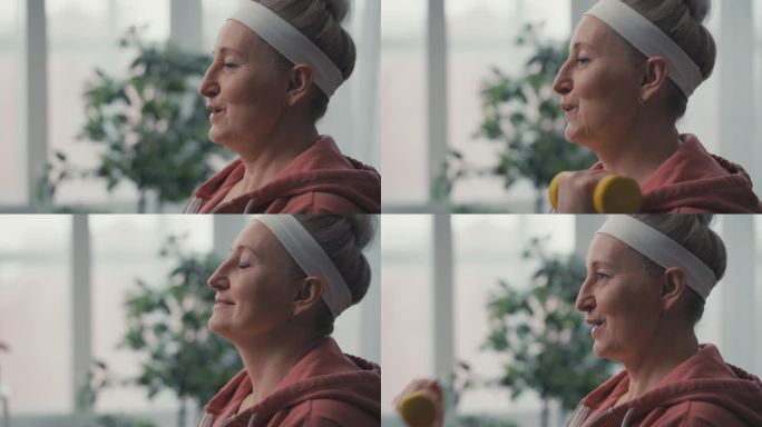 中年妇女用哑铃锻炼，在家锻炼，积极的生活方式