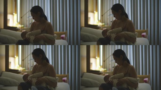 亚洲母亲在夜晚的卧室里给女儿哺乳。