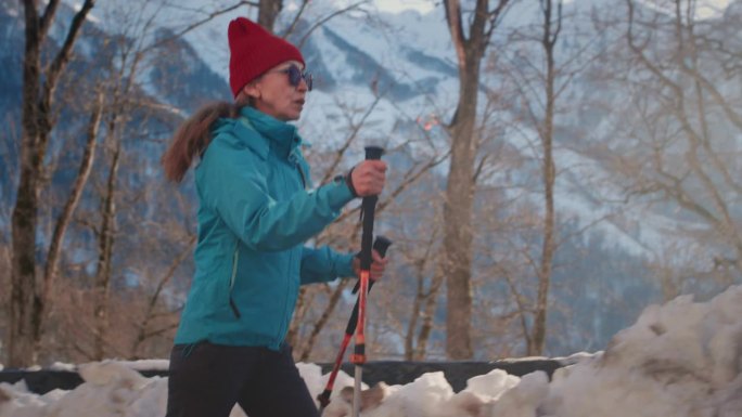 一位老妇人走过雪地。老年女性冬季登山。主动退休年龄