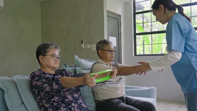 物理治疗师帮助老年人在家里举起运动橡皮