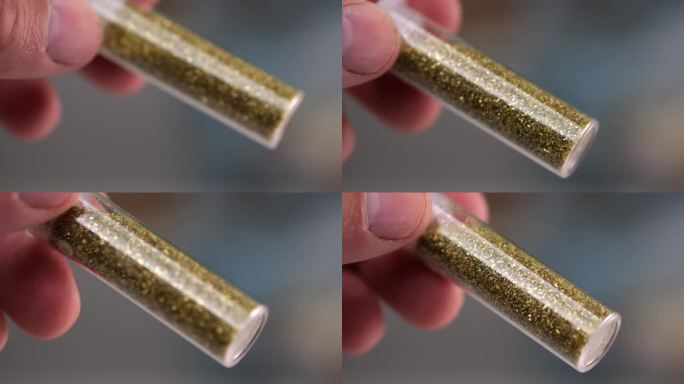 一个男人的手旋转着一个装满闪闪发光的小点的玻璃罐子，慢镜头检查质量。