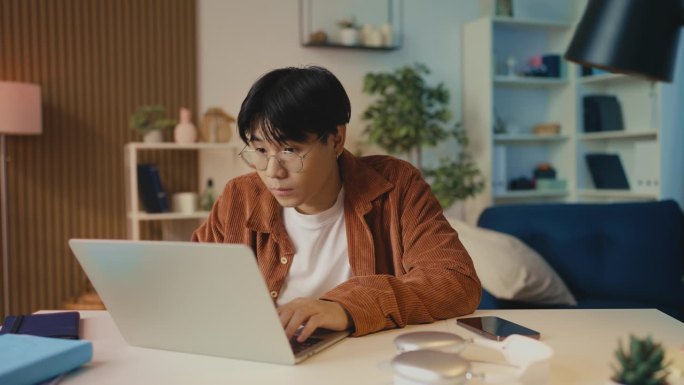 年轻的亚洲人收到电子邮件的好消息，彩票或资助的赢家