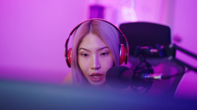 亚洲漂亮的电子竞技女性玩家在电脑上玩在线视频游戏。有吸引力的年轻女孩游戏玩家感到快乐，享受科技直播，