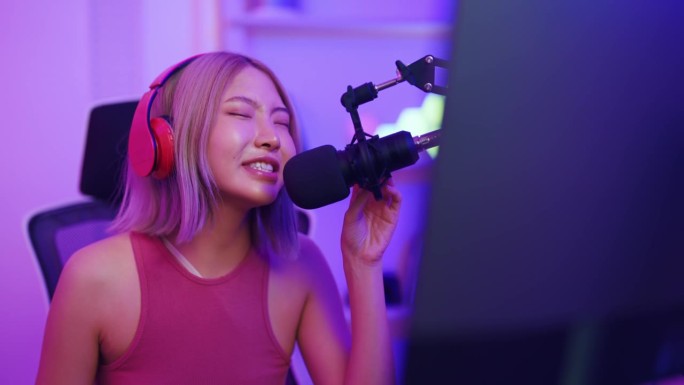 亚洲漂亮的电子竞技女性玩家在电脑上玩在线视频游戏。有吸引力的年轻女孩游戏玩家感到快乐，享受科技直播，