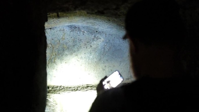 一群徒步旅行者在法兰基吉纳大道上探索伊特鲁里亚墓穴的深处。