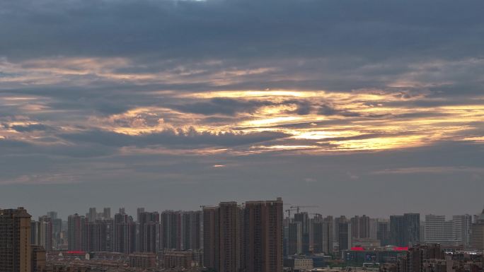 城市日落穿透云层的金光