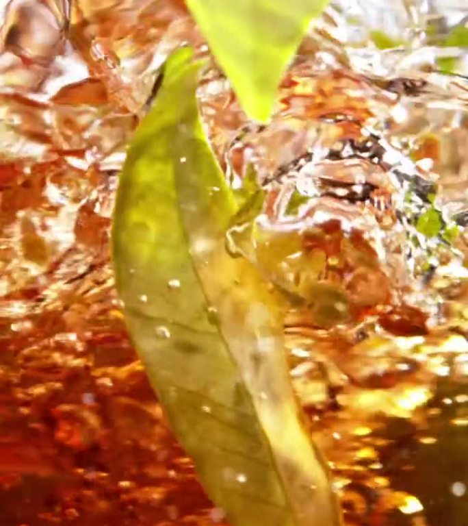 超慢动作：在旋转的水中混合黑茶和茶叶。