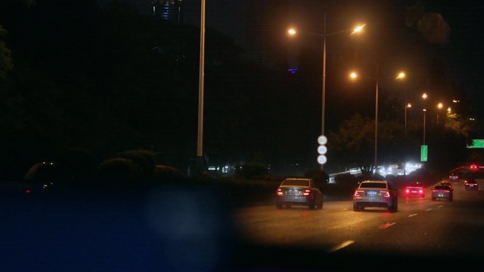 夜晚驾驶车窗外城市夜景下雨街道