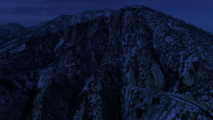 夜间冬季山脉公路航拍雪景，昼夜交替。