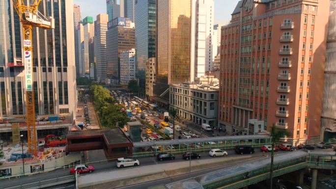 中国香港 - 2025年2月2日：繁忙的城市街道上满是车辆和摩天大楼，沐浴在明亮的晨光下。