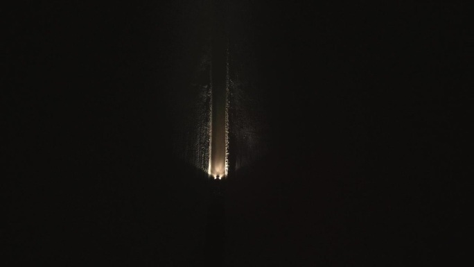 汽车在夜间雪-covered小路上行驶的空中俯视图