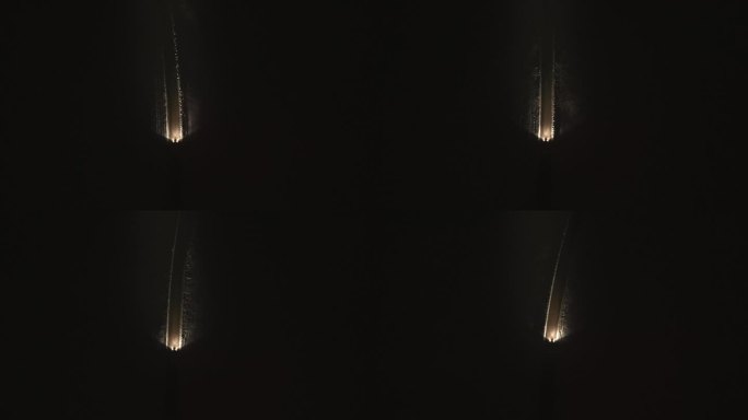 汽车在夜间雪-covered小路上行驶的空中俯视图