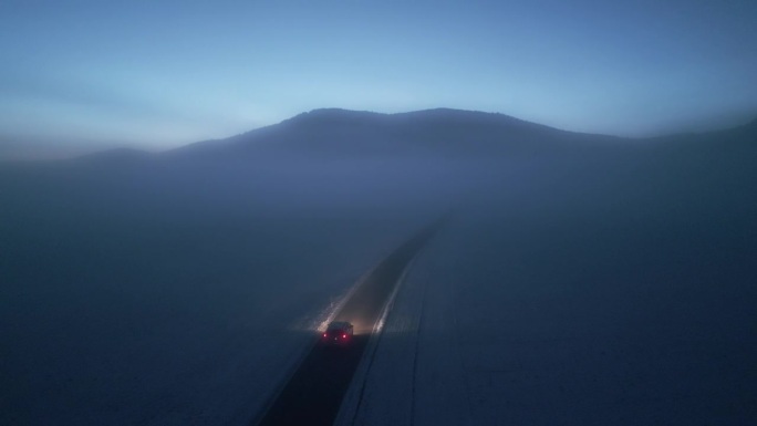 阴森的冬季风景，孤独道路上的汽车鸟瞰图。