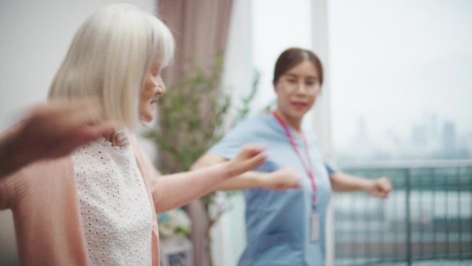 护士在家中帮助老年女性进行物理治疗。