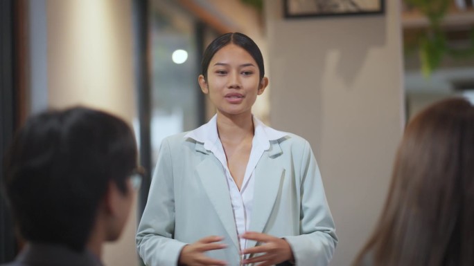 自信的女商人在会议上向团队展示战略。