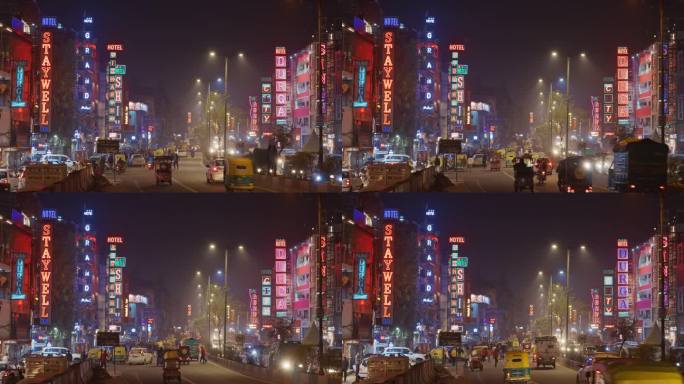 新德里，德里，印度。德什·班杜·古普塔路上的夜间交通。人们、汽车、摩托车、三轮车在夜间街道上行驶。夜