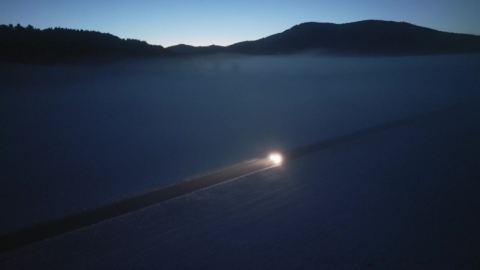 安静的冬季风景，孤独的道路上汽车的航拍照明。