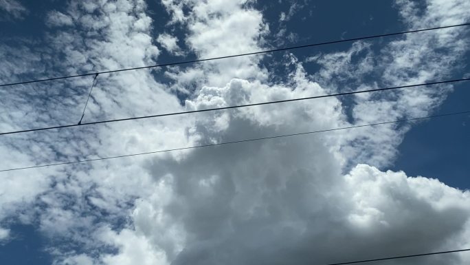列车运行中的蓝天白云电线交织
