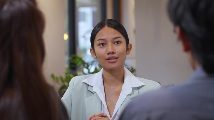 专注的女商人向团队展示销售报告。