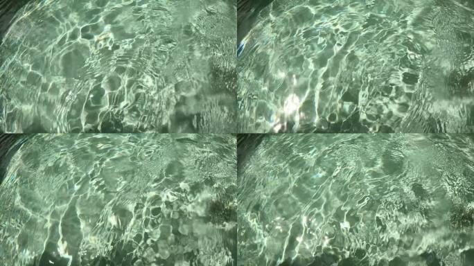 户外游泳池的水波，阳光透过水面慢动作场景。