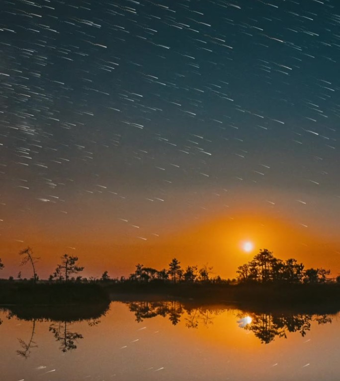 日落与月亮在水面上升起。夜晚湖泊、沼泽、湿地自然风光。延时摄影星空与银河，闪烁的星星。水面上的星光倒