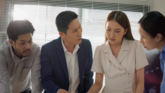 亚洲商务团队专注于在办公室审查项目策略的笔记本电脑。
