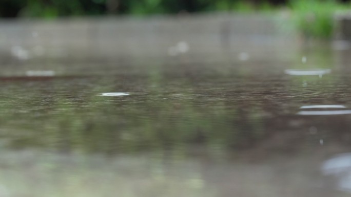 雨滴落在地面积水上溅起水花慢镜