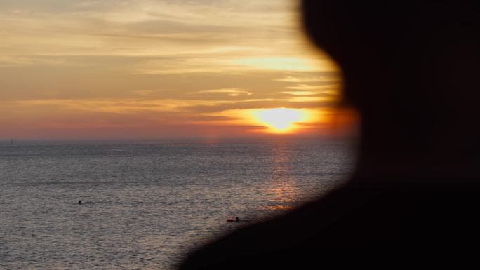 一名孤独的男子站在海边看夕阳