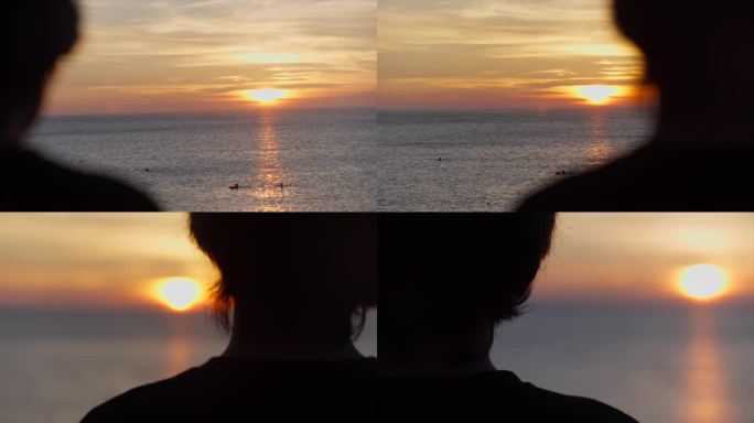 一名孤独的男子站在海边看夕阳