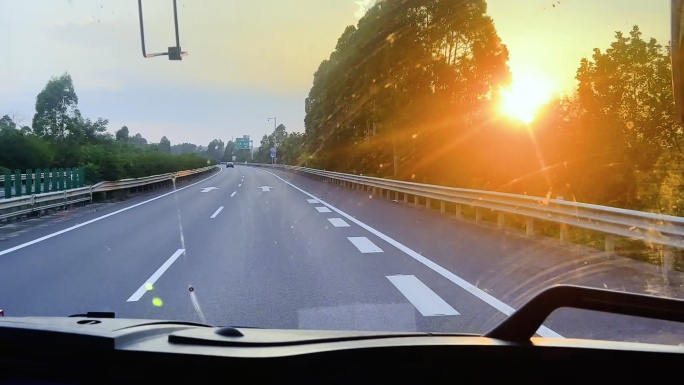 长途客车日落行驶在高速路上