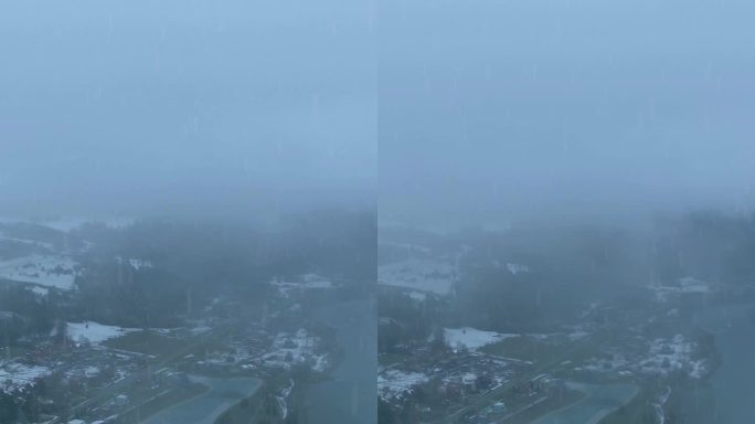 冬季风景展现了一个宁静的村庄，笼罩在雾霭中，河流、山丘和覆盖着雪的土地。