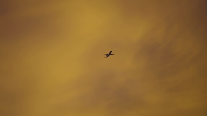 飞机穿越金色云层夕阳下的飞行