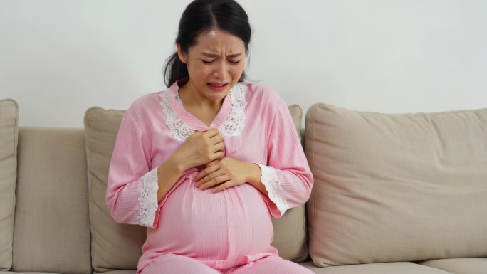 孕妇家中沙发上双手抚肚 孕妇临产阵痛难忍