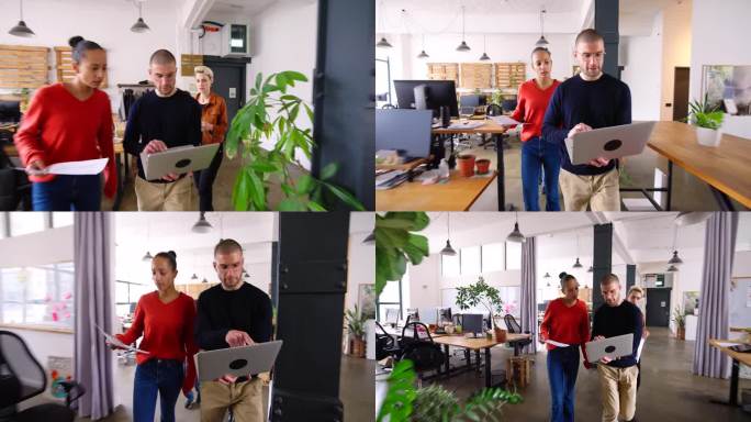 一个男人和同事在初创公司办公室里走动，讨论新的商业项目。