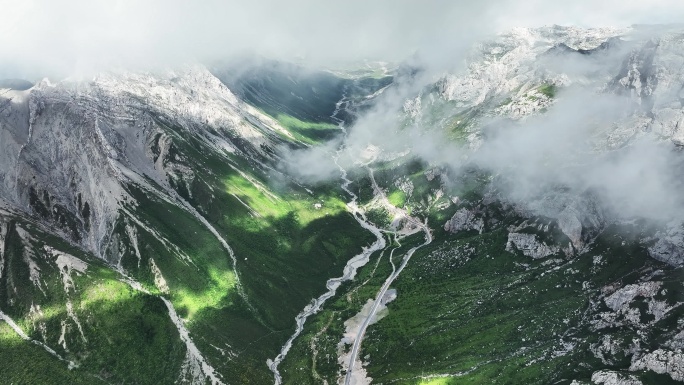 蓝天白云下甘南扎尕那的山脉和山谷中的公路