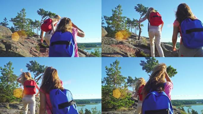 女人在徒步旅行中帮助朋友攀爬岩石山丘。