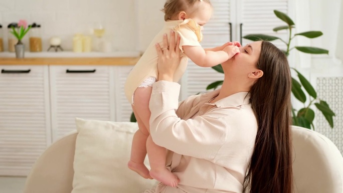 一位母亲抱着婴儿，温柔地在家中拥抱着她的小孩，母爱与教育，关怀，一位母亲在和孩子玩耍。