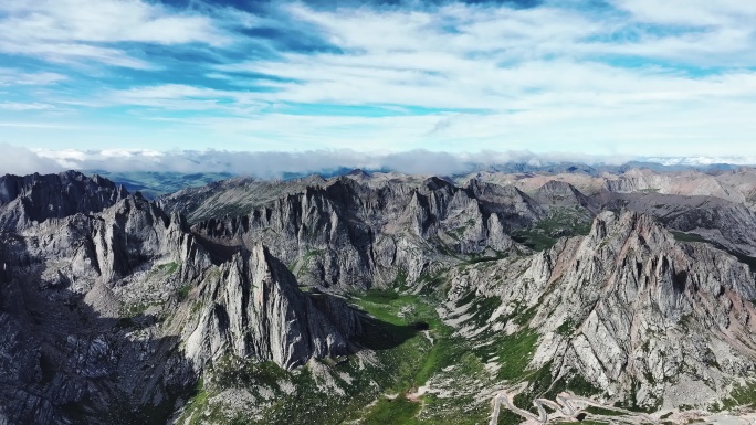 航拍蓝天白云下莲宝叶则的群峰和山谷