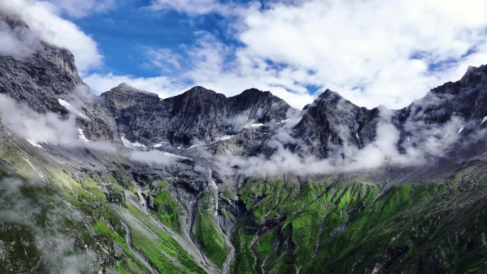 航拍蓝天白云下四姑娘山的群峰和山谷